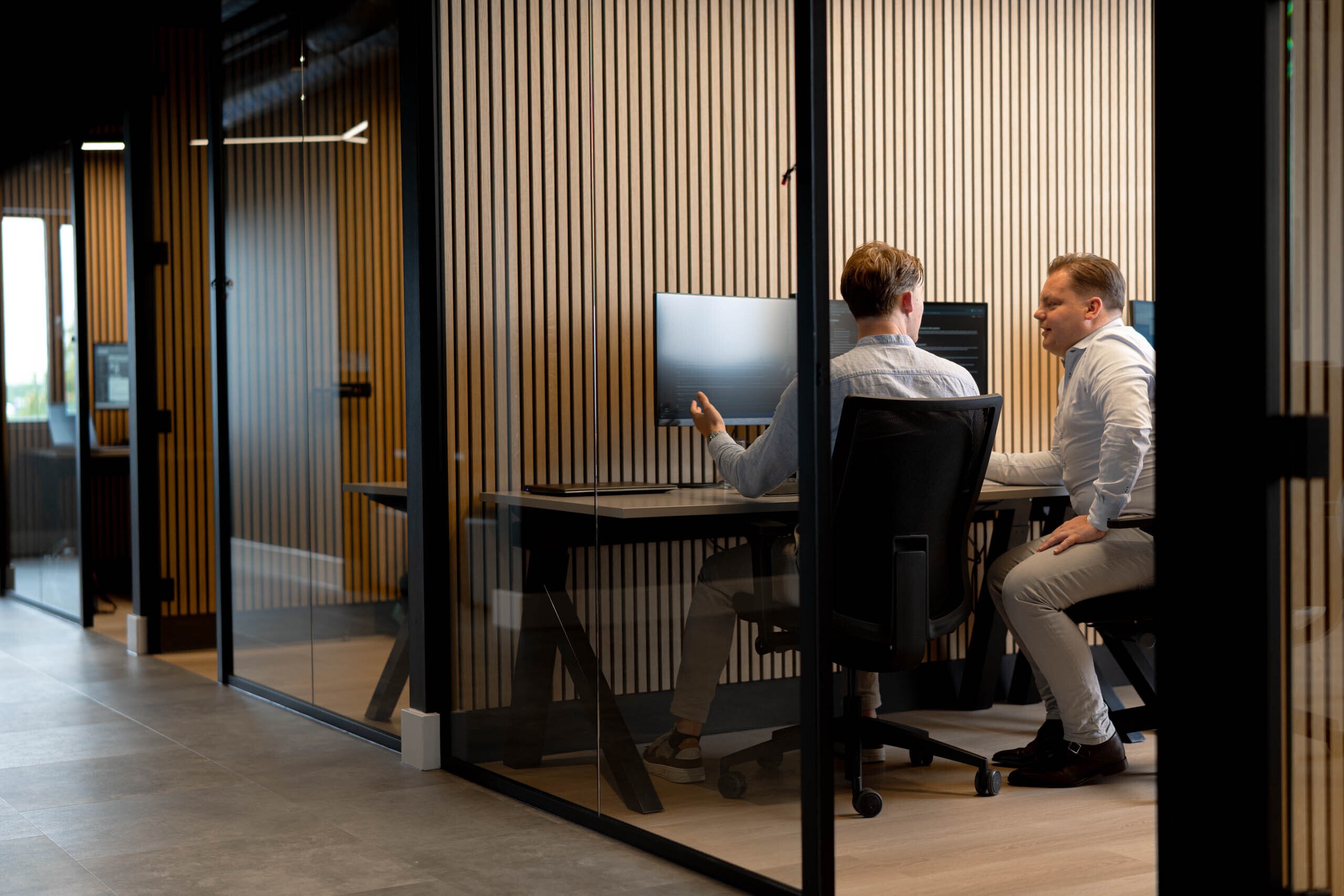 Collegas overleg glazen kantoorruimte accountone