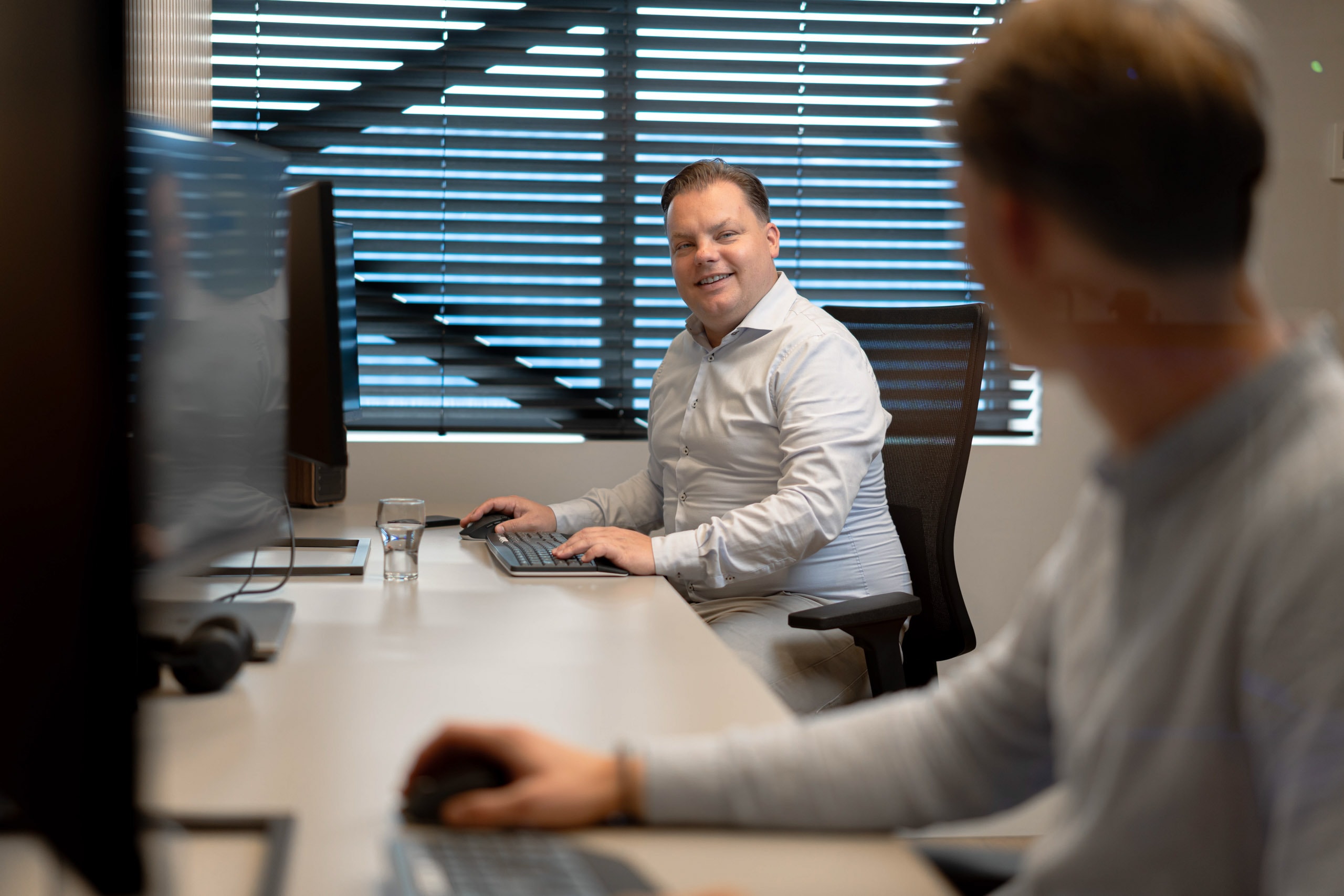 Medewerker glimlachend gesprek bureau accountone