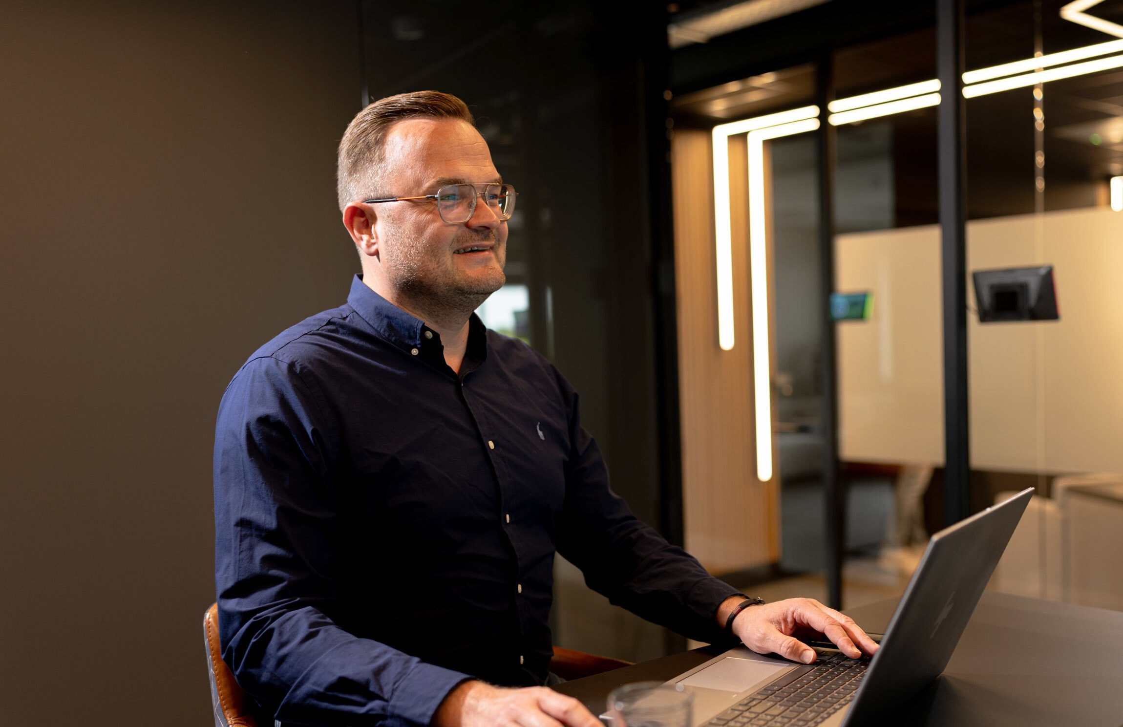 Medewerker glimlachend laptop kantoor accountone